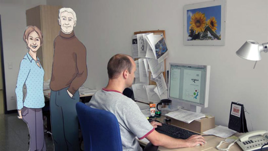 A man working next to two cardboard cutouts of personas.