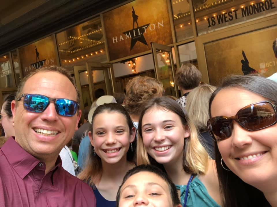 Family photo outside of Hamilton the Musical theater
